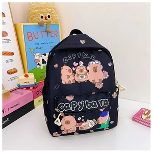 Close-up of deep blue Capybara cartoon backpack for kids on a desk with books