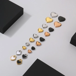 Macro view of heart-shaped pendants in gold, silver and rose gold with enamel inlay
