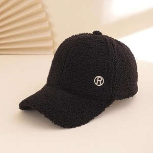 Black lamb wool baseball cap with rhinestone R metal logo on a minimalist background