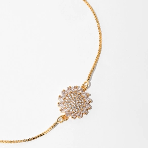Macro detail of gold tree of life pendant with zircon inlay on a delicate box chain