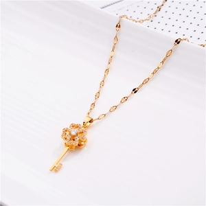 Close-up of golden spinning key necklace with sparkling zircon clover details