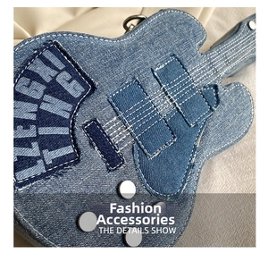 Detailed macro of vintage denim guitar-shaped crossbody bag with white stitching and rivets
