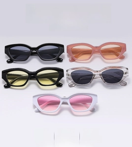 Flat lay display of colorful Y2K cat eye sunglasses in black, orange and pink tones