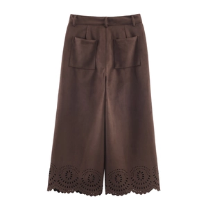 Detail of dark brown trousers with hollow lace hem and suede-like texture fabric