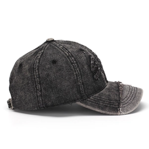 Close-up of distressed denim baseball cap with skull embroidery and metal buckle