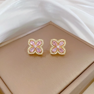 Close-up of pink flower earrings with pear-shaped cubic zirconia in a gold setting