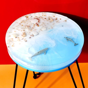 Macro detail van ronde ocean-thema hars bijzettafel met schelpen en dolfijn 3D-effect