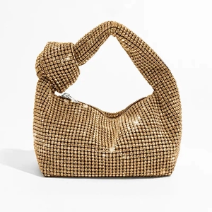 Close-up of golden rhinestone mesh handbag with sparkling crystals and knotted handle detail