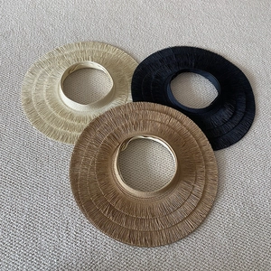 Detailed straw weave textures of beige, black, and coffee sun hats on a soft rug