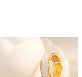 Macro shot of gold and white enamel open ring featuring unique textured irregular edges