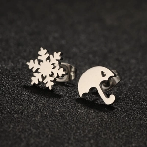 Detail of asymmetric stainless steel stud earrings featuring snowflake and umbrella designs