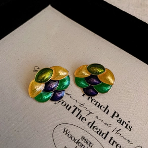 Detailed macro view of enamel flower earrings with layered petals in yellow and purple
