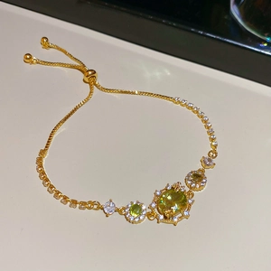 Detail of 18k gold plated adjustable bracelet with green and white zircon crystals