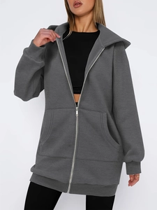 Detail of gray oversized zip-up hoodie featuring front pocket and ribbed sleeve cuffs