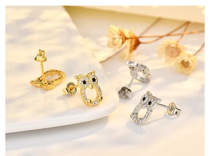Macro shot of owl stud earrings with S925 silver hallmark and sparkling zircon stones