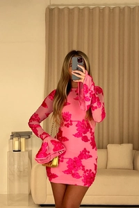 Détail de la broderie florale sur la robe rose à manches évasées et texture du tissu