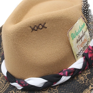 Detail of camel wool felt western hat with braided band, spotted feather and tag