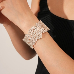 Detail of silver hollow heart clover pattern bracelet worn on model wrist