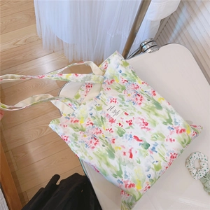Detail view of cotton tote bag with colorful watercolor floral print on a white chair