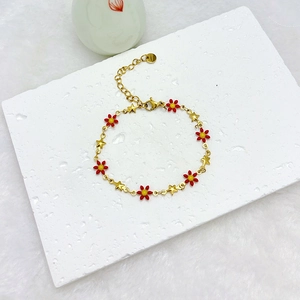 Detail of 18k gold plated chain with red enamel daisies and gold stars on stone