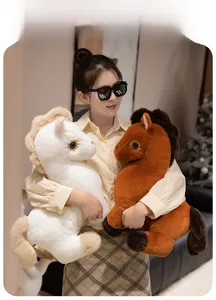Close-up of soft plush white and brown horse toys held by a model in a cozy home setting