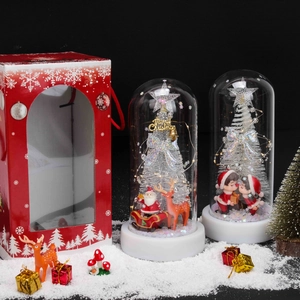 Detailed view of Santa and reindeer glass dome with LED lights and a red gift box