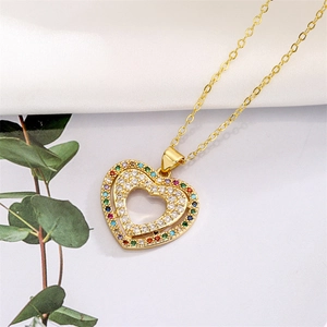 Close-up of a gold heart necklace with vibrant rainbow gemstones and clear zircon inlay