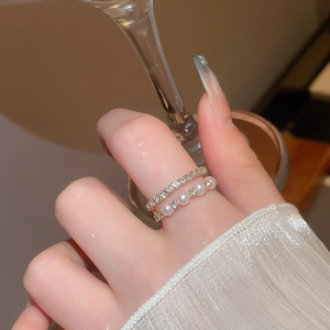 Detail of elegant double-layer ring with sparkling rhinestones and white pearls on model