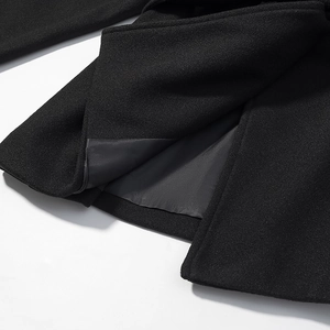 Detailed view of the split hem and smooth lining on this black wool winter coat