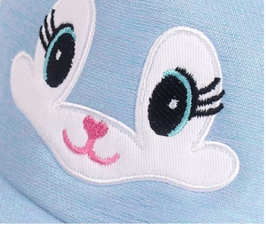Dettaglio del ricamo a forma di coniglio sulla maglia azzurra del cappello da bambino
