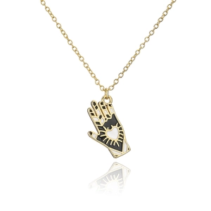 Detail of 18K gold-plated hand-shaped pendant with black enamel and a white heart center