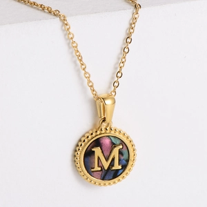 Gold round letter M pendant necklace with iridescent shell inlay and slim gold-plated chain