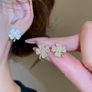 Close-up of elegant four-leaf clover stud earrings with sparkling pavé zircons