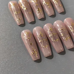Luxury nude pink press-on nails with gold baroque embossed patterns in long coffin shape