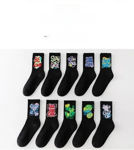 Macro detail of ten pairs of black crew athletic socks featuring vibrant graffiti designs