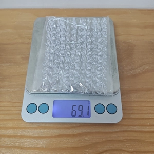 Clear acrylic icicle ornaments on digital scale showing a weight of 69.1 grams