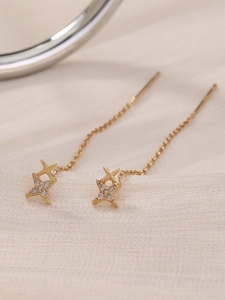Macro shot of gold-plated star tassel earrings featuring sparkling zircon stone settings