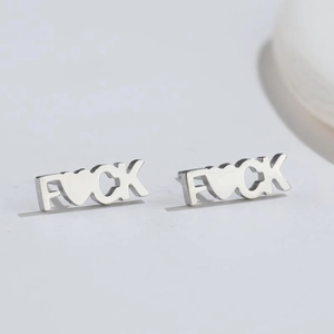 Detailed view of silver FUCK letter earrings with a heart symbol and metallic finish