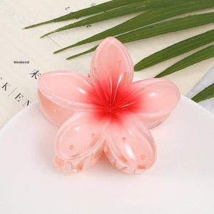Close-up of pink translucent plumeria flower claw clip with red gradient core