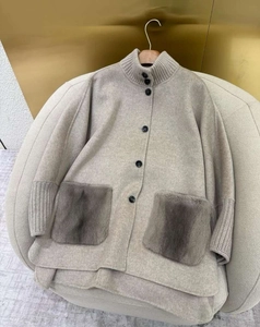 Detail of beige wool coat featuring textured faux fur pockets and single-breasted buttons