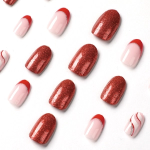 Festive red glitter press-on nails with silver French tips and wavy patterns for Christmas