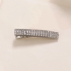 Sparkling silver alloy hair clip with clear rhinestones on a minimalist beige background