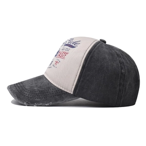 Detail of washed cotton baseball cap featuring vintage prints and distressed brim edges
