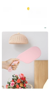 Close-up of pink bed sheet tucker tool showing the ergonomic handle and wedge shape