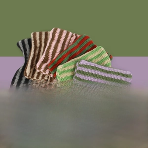Detailed stack of various colored striped knit beanies featuring devil ear design