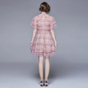 Back view of pink tiered lace cake dress with ruffled layers and short sleeves
