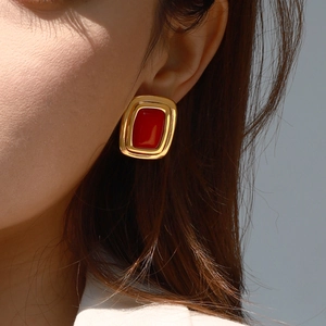 Vintage gold square stud earrings with red gemstones on model from a side profile view
