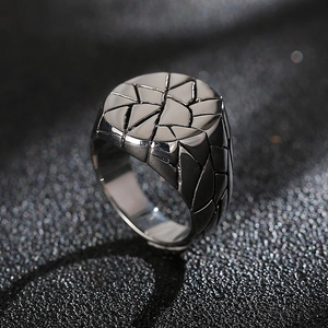 Macro view of men's wide stainless steel ring with black geometric cracked texture