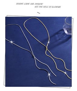 Detail of adjustable gold and silver snake chains with sliding clasp on blue background