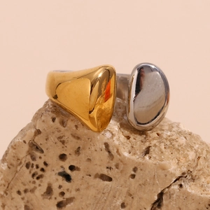 Détail d'une bague bicolore plaqué or 18 carats sur un fond en pierre naturelle